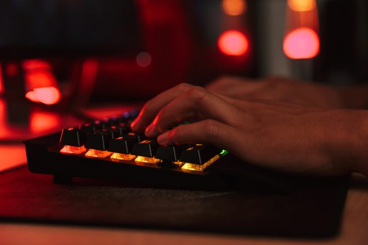 Hands of teenage gamer boy playing video games on computer